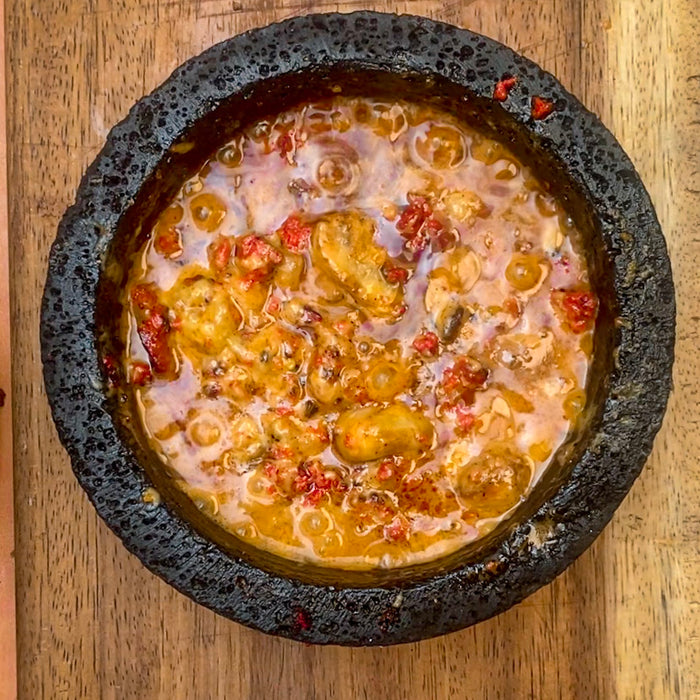 Queso fundido a tres capas flameado en Mezcal en quesera de Piedra volcánica